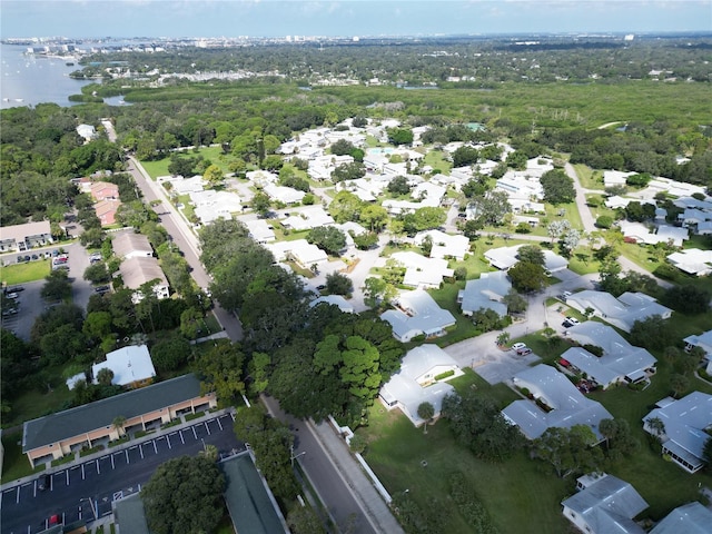 drone / aerial view with a residential view, a water view, and a view of trees