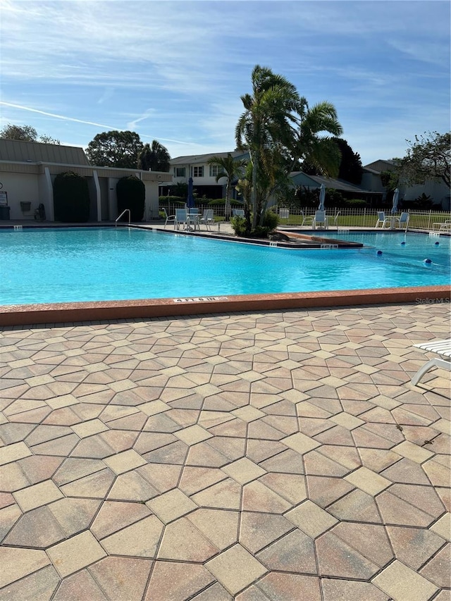 community pool featuring a patio and fence