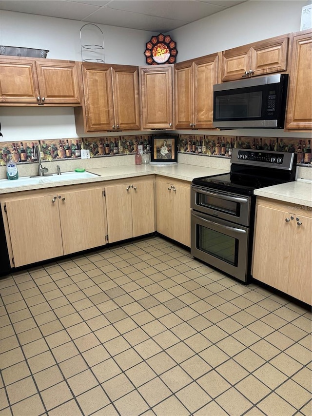 kitchen featuring stainless steel appliances, light countertops, and a sink