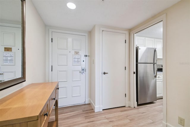 foyer entrance featuring a textured ceiling and light wood-type flooring