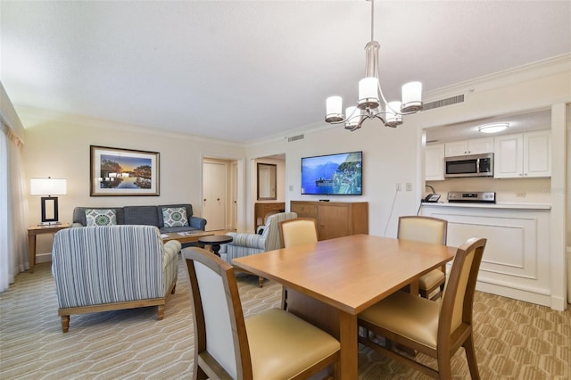 carpeted dining space featuring ornamental molding and an inviting chandelier