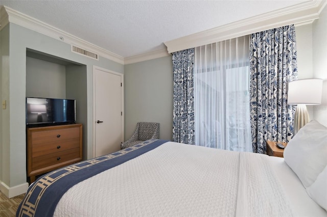 bedroom featuring ornamental molding and a textured ceiling