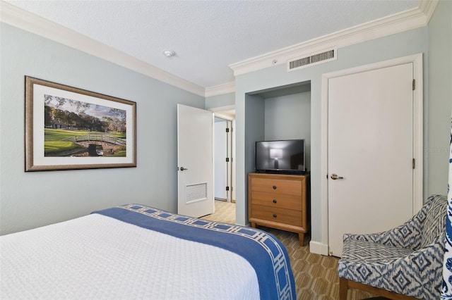 bedroom with a textured ceiling and crown molding