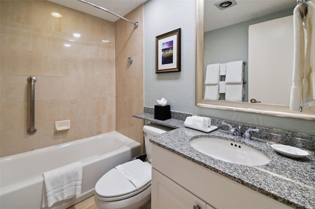 full bathroom featuring tiled shower / bath combo, large vanity, and toilet