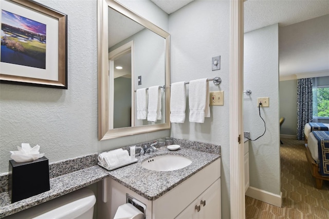 bathroom with toilet, vanity, and a textured ceiling