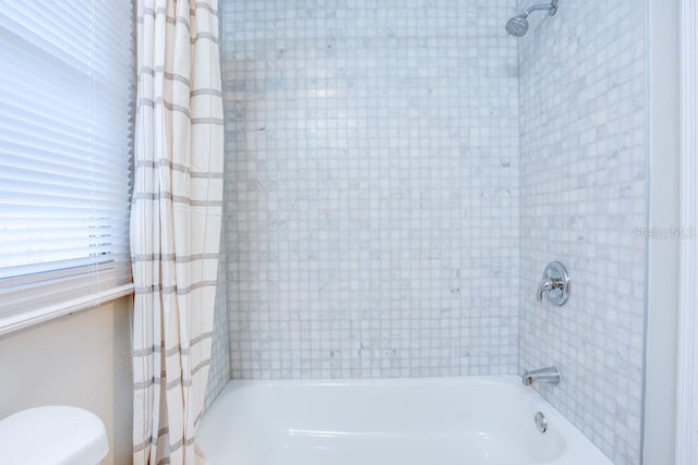 bathroom with shower / tub combo with curtain and toilet