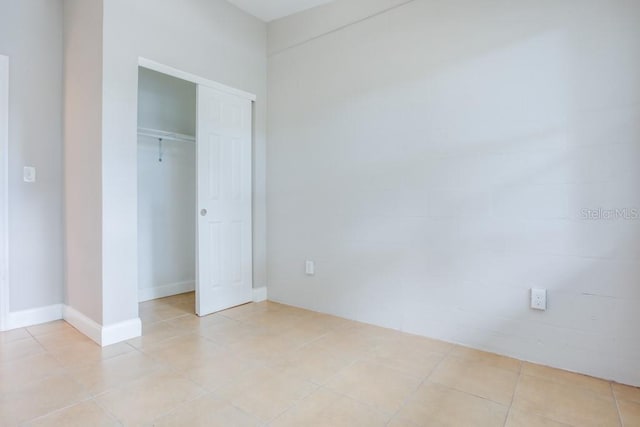 unfurnished bedroom with light tile patterned floors and a closet