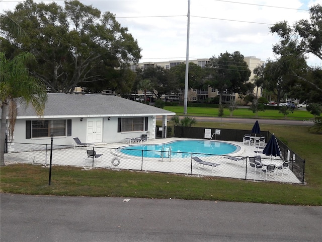 view of swimming pool with a yard