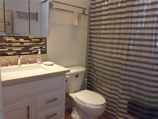 bathroom featuring vanity, toilet, and backsplash