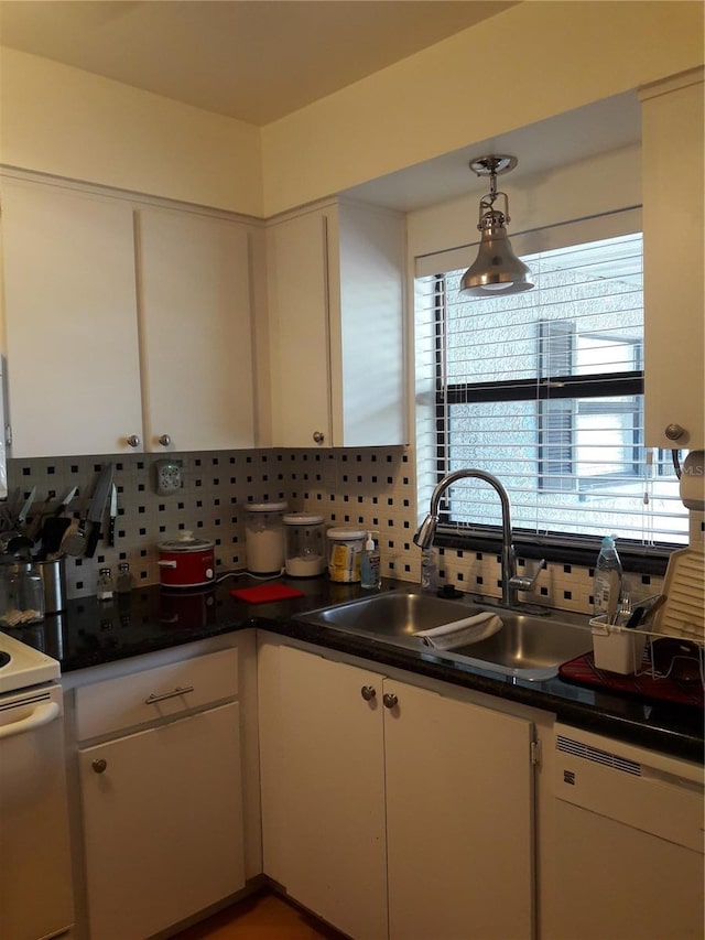 kitchen featuring decorative backsplash, white appliances, a healthy amount of sunlight, and decorative light fixtures