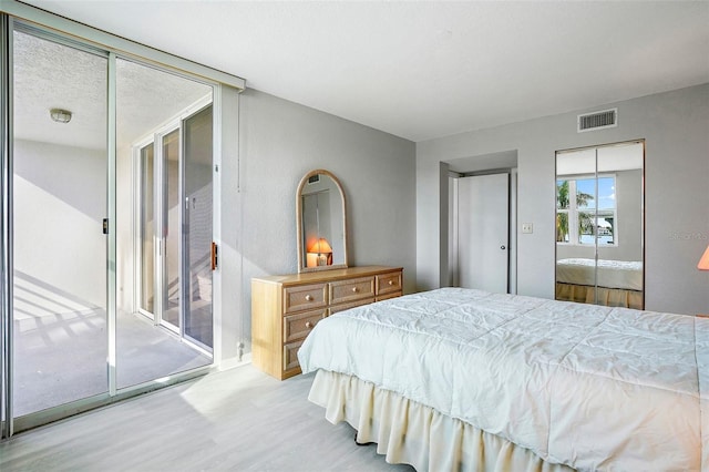 bedroom featuring a closet, light wood-type flooring, and access to outside