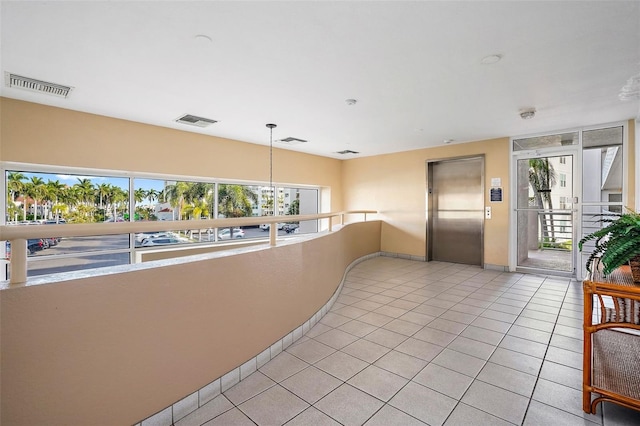 interior space featuring elevator and light tile floors