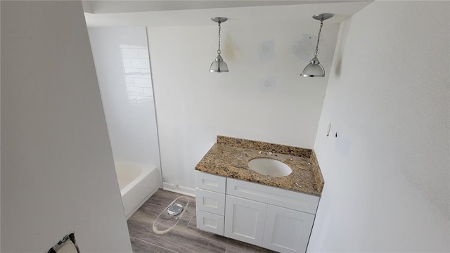 bathroom with vanity, tiled shower / bath, and hardwood / wood-style floors