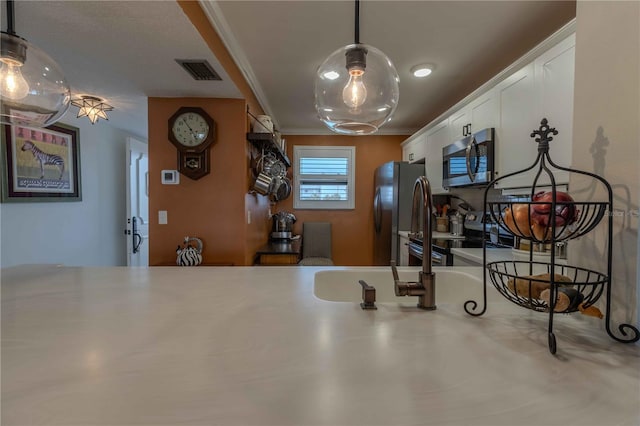 kitchen with white cabinets, range, pendant lighting, and black fridge