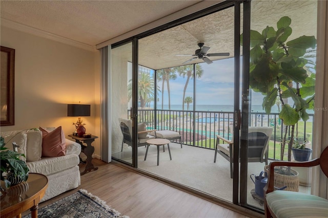 interior space featuring plenty of natural light, ceiling fan, and a water view