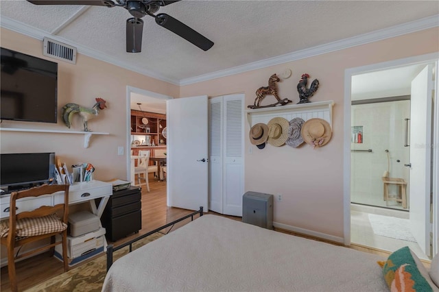 bedroom with a closet, ceiling fan, a textured ceiling, hardwood / wood-style floors, and crown molding