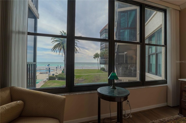 sitting room with hardwood / wood-style floors and a water view