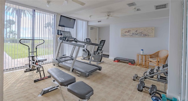 workout room with a textured ceiling, ceiling fan, and carpet