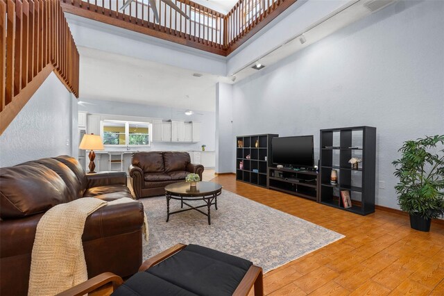 living room with wood-type flooring and a high ceiling