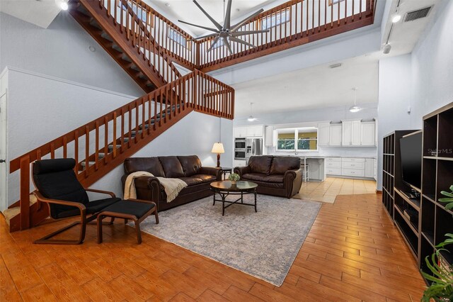 living room featuring light hardwood / wood-style floors and a high ceiling