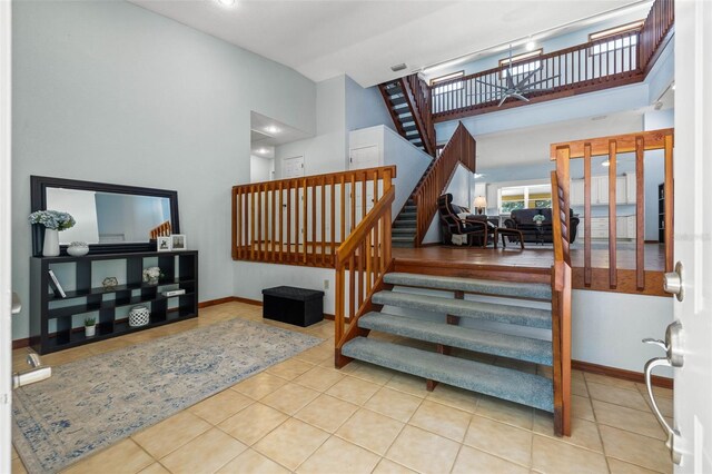 stairway with a high ceiling and light tile floors