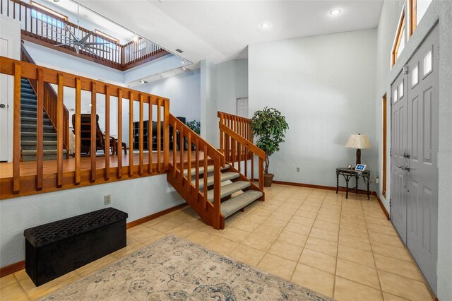 entryway featuring light tile floors and a high ceiling