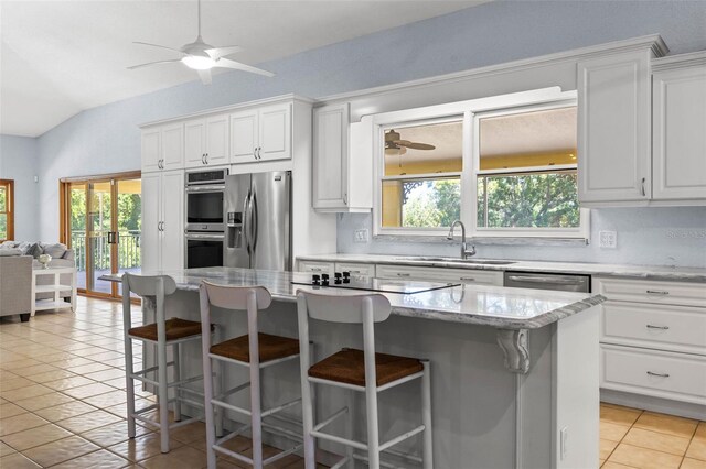 kitchen with backsplash, stainless steel appliances, ceiling fan, and vaulted ceiling