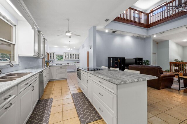 kitchen featuring sink, a healthy amount of sunlight, light tile floors, and white cabinetry