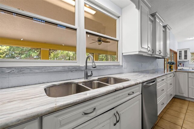 kitchen featuring light tile flooring, white cabinetry, sink, stainless steel dishwasher, and ceiling fan