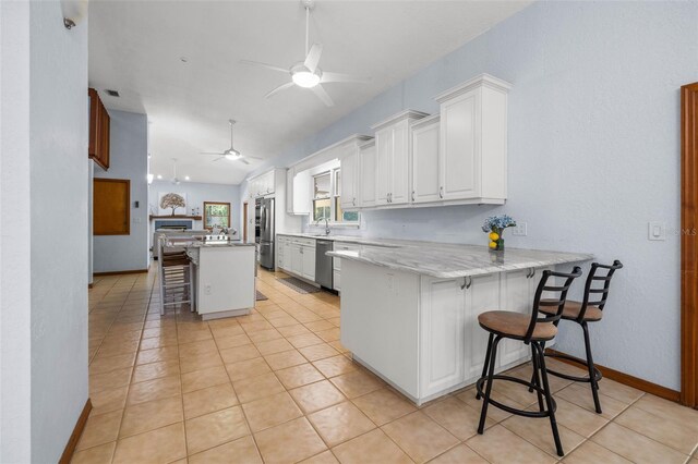 kitchen with ceiling fan, kitchen peninsula, white cabinetry, and light tile floors