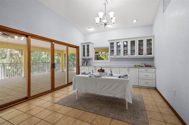 bedroom with access to exterior, light tile flooring, a chandelier, and multiple windows