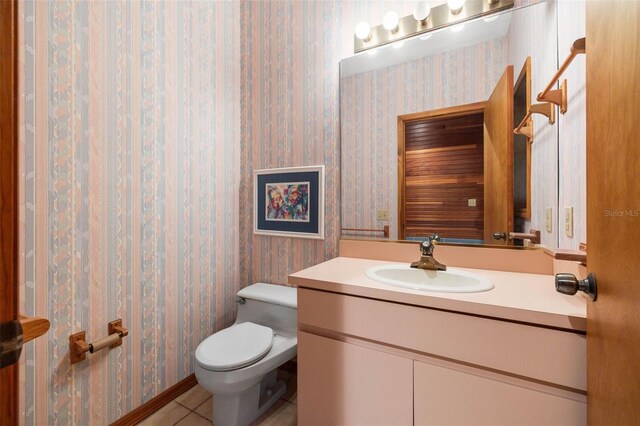 bathroom featuring tile floors, vanity with extensive cabinet space, and toilet