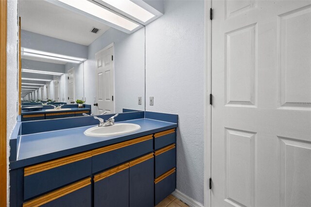 bathroom with tile flooring and large vanity