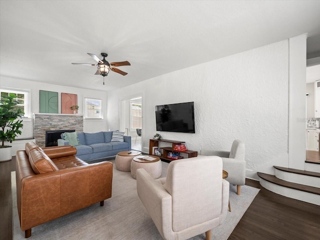 living room featuring a fireplace, hardwood / wood-style floors, and ceiling fan