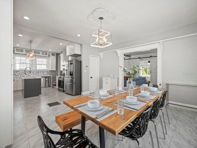 tiled dining space featuring an inviting chandelier and sink