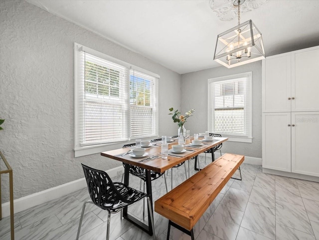 dining space featuring plenty of natural light, a notable chandelier, and light tile flooring