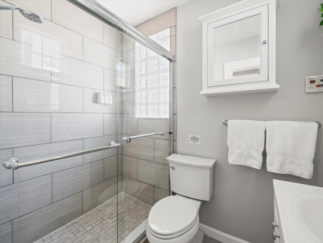 bathroom with a shower with door, vanity, and toilet