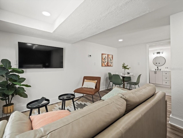 living room featuring hardwood / wood-style flooring, sink, and a textured ceiling