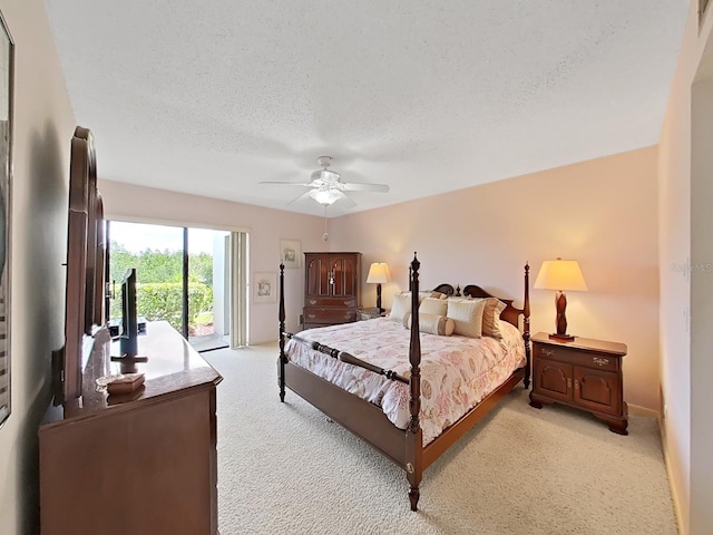 carpeted bedroom with access to exterior, a textured ceiling, and ceiling fan