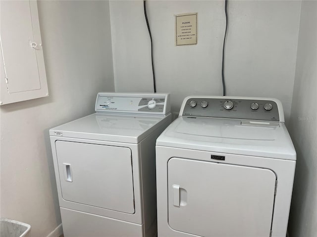 washroom featuring electric panel and washer and clothes dryer