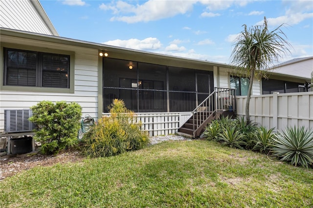 exterior space with a sunroom, a lawn, stairway, and fence