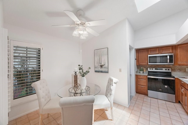 interior space with light tile patterned floors, appliances with stainless steel finishes, vaulted ceiling, and ceiling fan