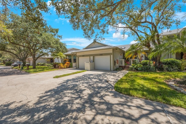 view of front of house featuring a garage, a front lawn, and concrete driveway