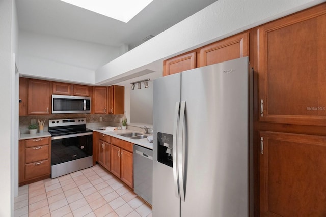 kitchen with sink, stainless steel appliances, light tile patterned floors, and tasteful backsplash