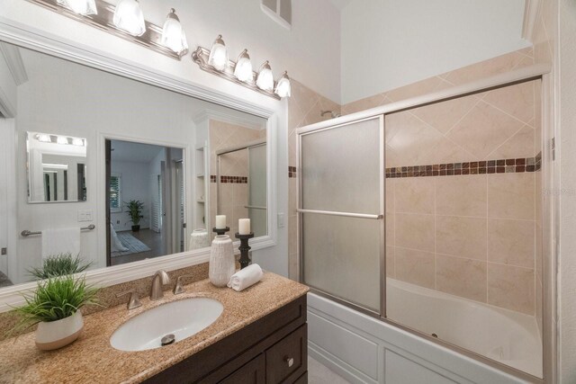 bathroom with shower / bath combination with glass door and vanity