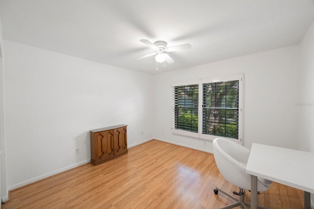 office area featuring a ceiling fan, baseboards, and light wood finished floors