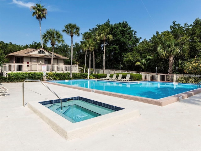 view of swimming pool with a hot tub