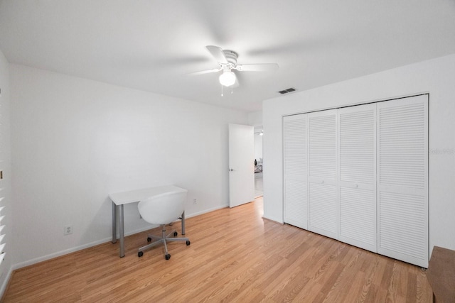 office with light wood-style floors, visible vents, ceiling fan, and baseboards