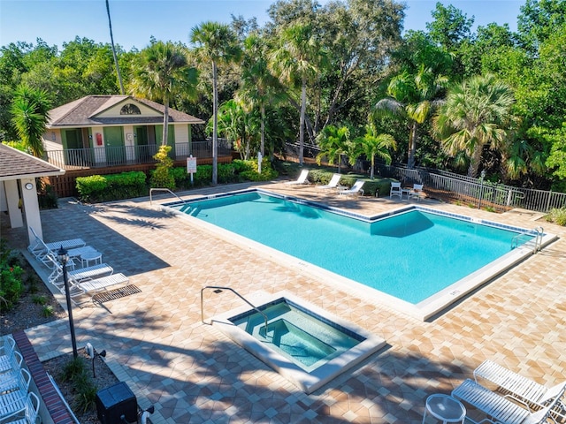 view of swimming pool with a hot tub and a patio