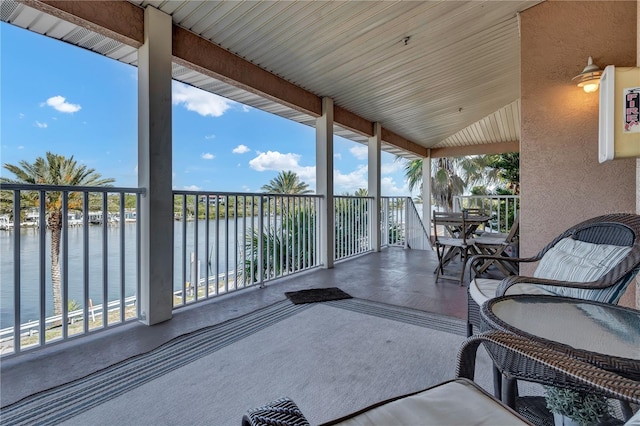 view of patio featuring a water view and a balcony
